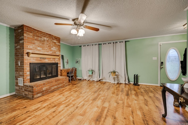 living room with a brick fireplace, crown molding, and light hardwood / wood-style flooring