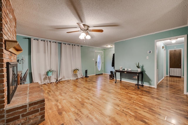 interior space featuring ornamental molding, a brick fireplace, and light hardwood / wood-style flooring