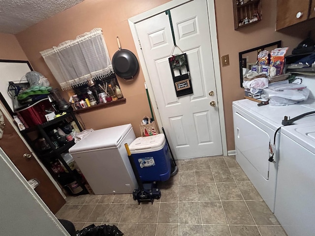 laundry room featuring separate washer and dryer, light tile patterned floors, cabinets, and a textured ceiling