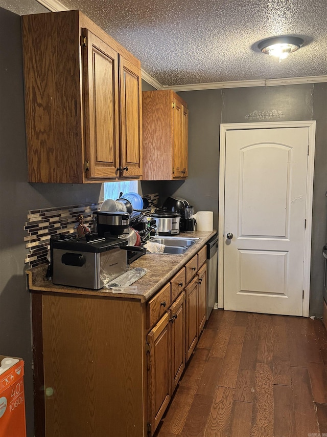 kitchen with dishwasher, sink, dark hardwood / wood-style flooring, ornamental molding, and a textured ceiling