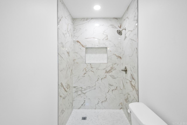 bathroom with tiled shower and toilet