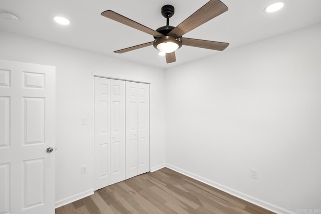 unfurnished bedroom featuring ceiling fan, hardwood / wood-style floors, and a closet