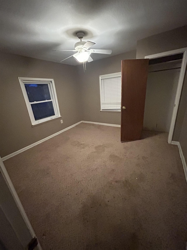 unfurnished bedroom featuring a closet, ceiling fan, and carpet