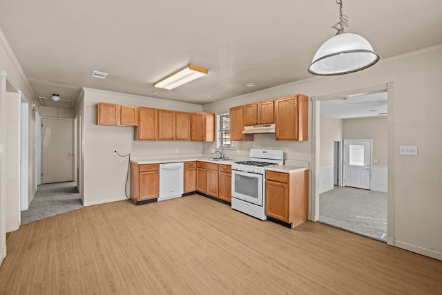 kitchen with pendant lighting, sink, light wood-type flooring, ornamental molding, and white appliances