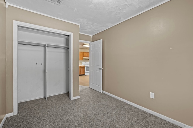 unfurnished bedroom featuring ornamental molding, a closet, and carpet flooring