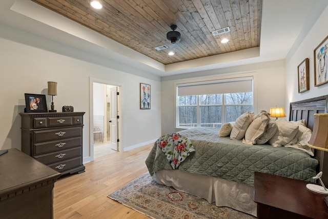 bedroom featuring a raised ceiling, connected bathroom, wood ceiling, and light hardwood / wood-style floors