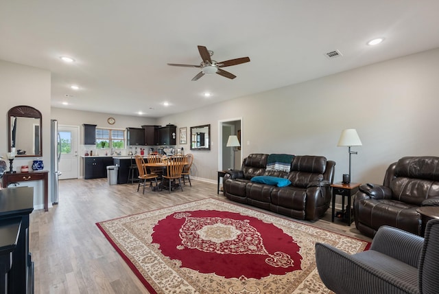 living room featuring ceiling fan and light wood-type flooring