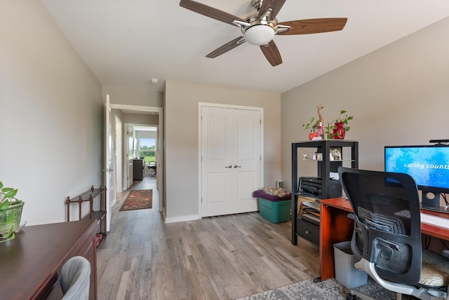 office with light hardwood / wood-style flooring and ceiling fan