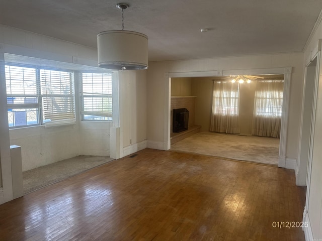 1013 Elm St, Coal Hill, AR 72832 - unfurnished living room with hardwood / wood-style flooring, ceiling fan, and a fireplace