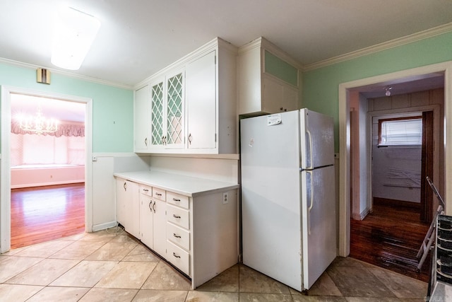 kitchen featuring ornamental molding, white fridge, and white cabinets