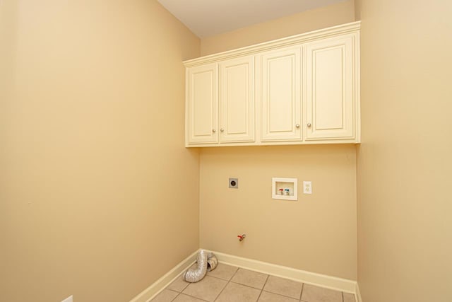 clothes washing area with light tile patterned floors, electric dryer hookup, hookup for a washing machine, cabinets, and hookup for a gas dryer