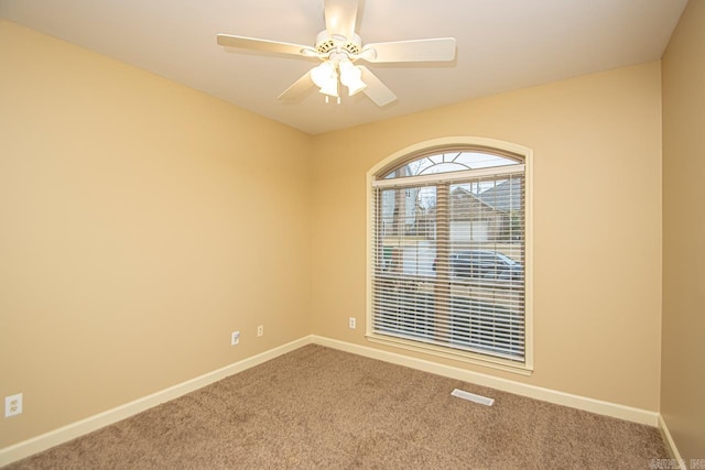 spare room with ceiling fan and carpet