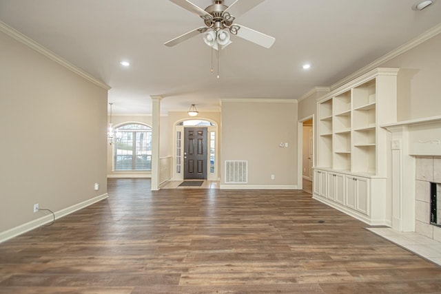 unfurnished living room featuring ornamental molding, a tile fireplace, and dark hardwood / wood-style floors