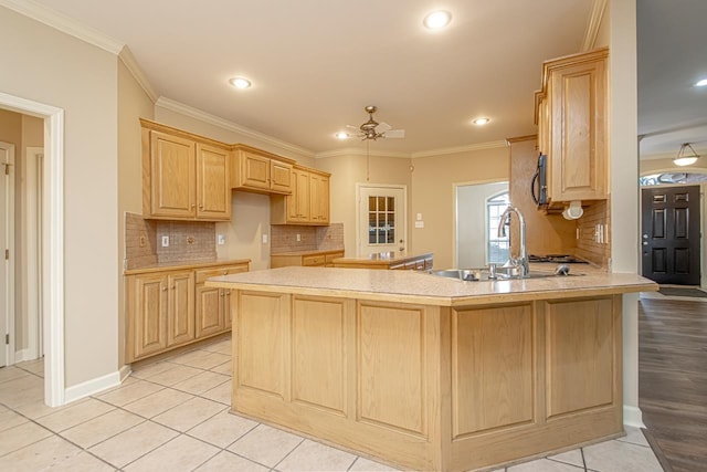 kitchen with ornamental molding, sink, light brown cabinets, and kitchen peninsula