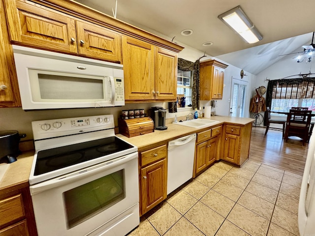 kitchen featuring light tile patterned flooring, lofted ceiling, sink, ceiling fan, and white appliances