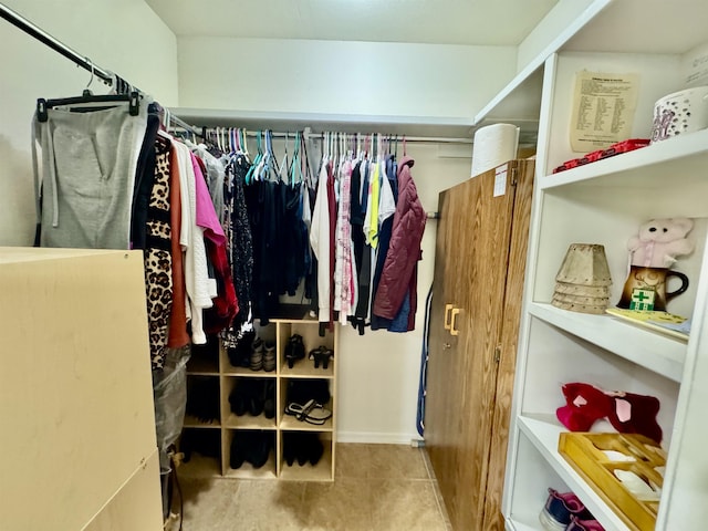 walk in closet with light tile patterned floors