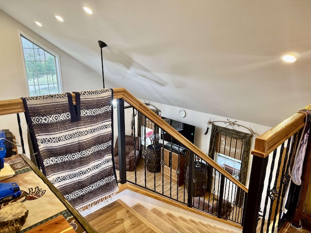 stairway featuring vaulted ceiling and wood-type flooring