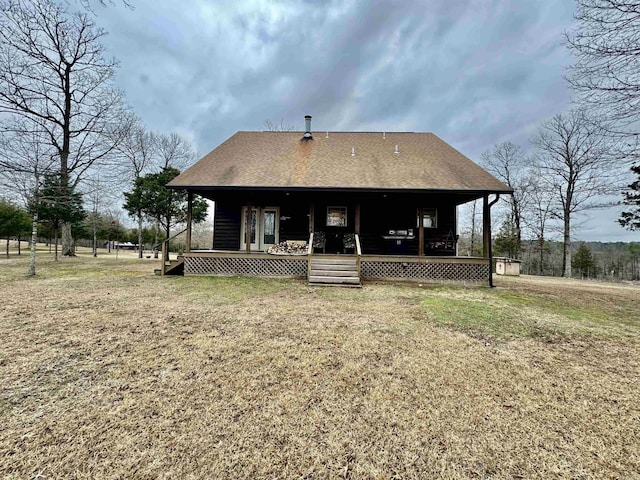 back of house featuring covered porch and a lawn