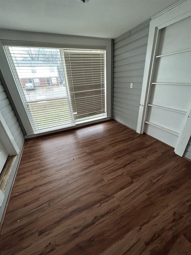 interior space featuring dark hardwood / wood-style floors and wood walls