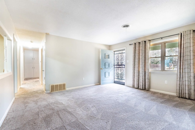 empty room with carpet flooring, baseboards, and visible vents