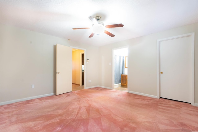 unfurnished bedroom featuring light carpet, ceiling fan, ensuite bathroom, and baseboards