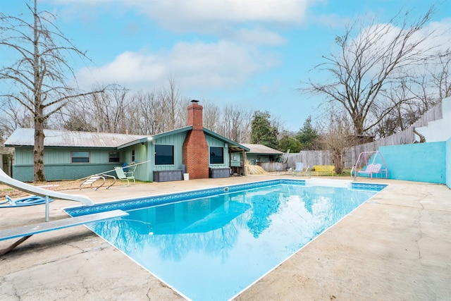 view of swimming pool with central AC, fence, a water slide, a fenced in pool, and a patio area