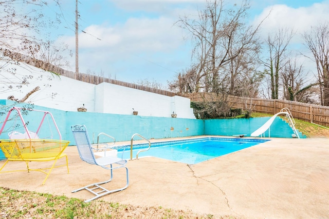 view of swimming pool with a fenced in pool, a patio, a water slide, and a fenced backyard