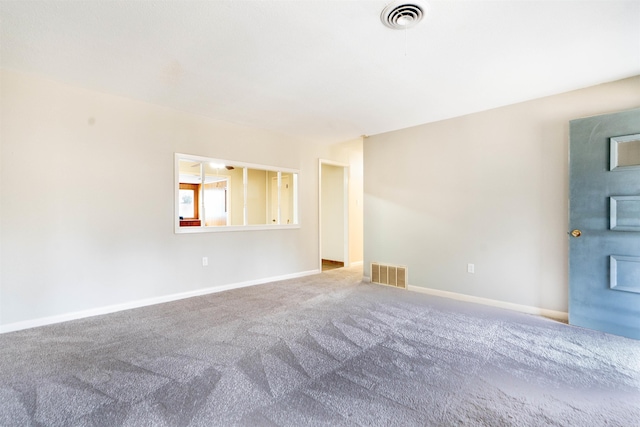 carpeted empty room featuring baseboards and visible vents