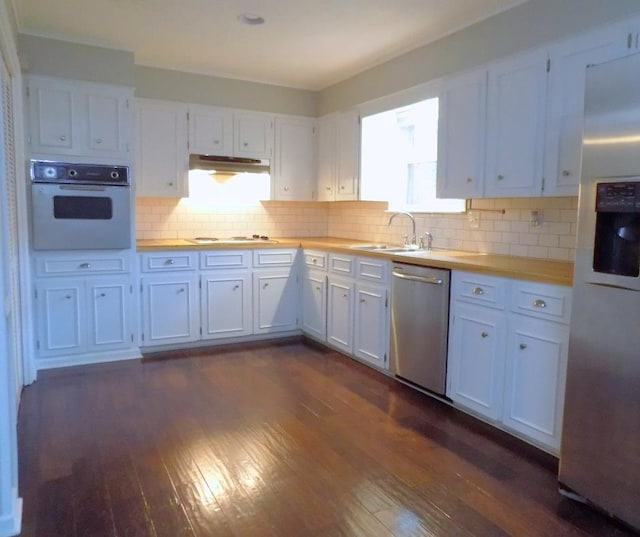 kitchen featuring appliances with stainless steel finishes, sink, white cabinets, and butcher block countertops