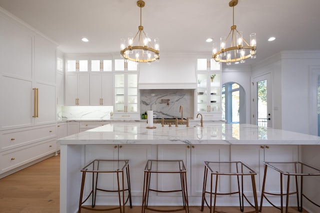 kitchen with pendant lighting, light stone counters, a kitchen bar, and a spacious island