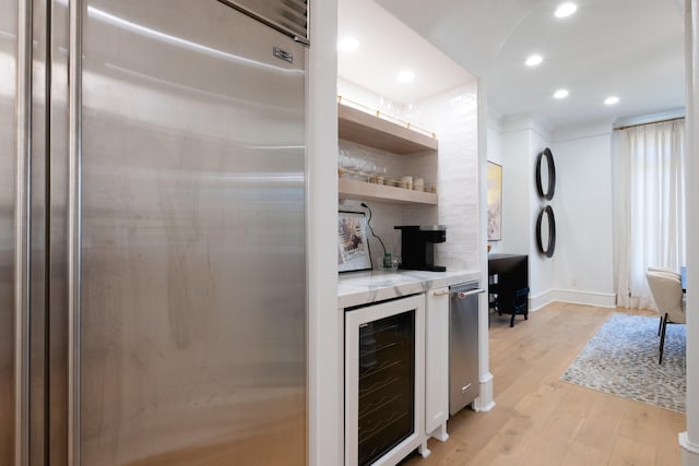 kitchen with light hardwood / wood-style flooring, beverage cooler, and stainless steel built in fridge