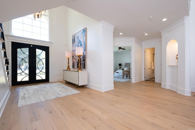 foyer entrance featuring french doors, ornamental molding, and light hardwood / wood-style flooring