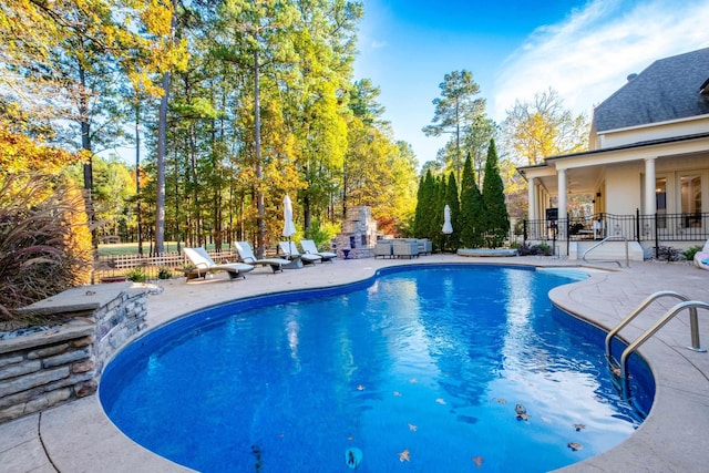 view of swimming pool featuring a fireplace and a patio area