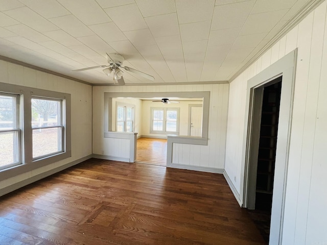 empty room with crown molding, ceiling fan, and dark hardwood / wood-style flooring