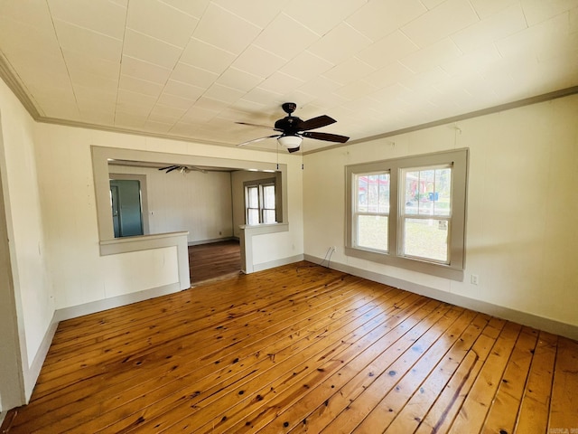 unfurnished room featuring crown molding, wood-type flooring, and ceiling fan