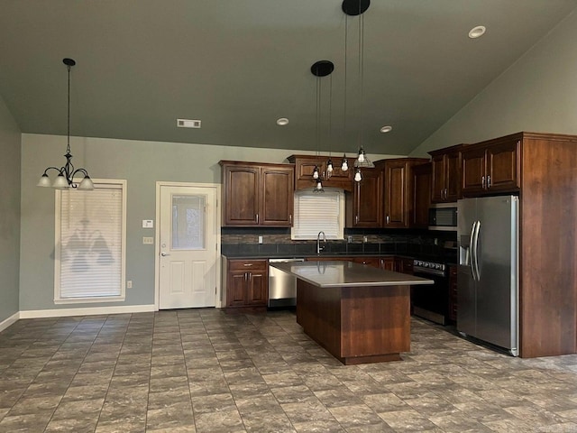 kitchen with sink, a center island, hanging light fixtures, stainless steel appliances, and decorative backsplash