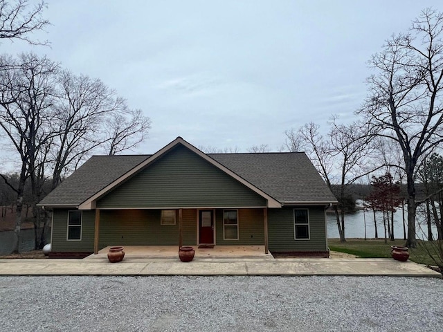 view of front facade with an outdoor fire pit, a patio area, and a shingled roof