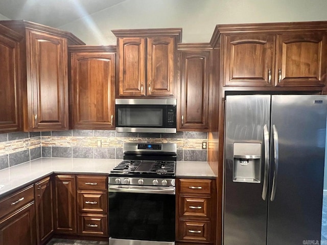 kitchen featuring tasteful backsplash, stainless steel appliances, and lofted ceiling