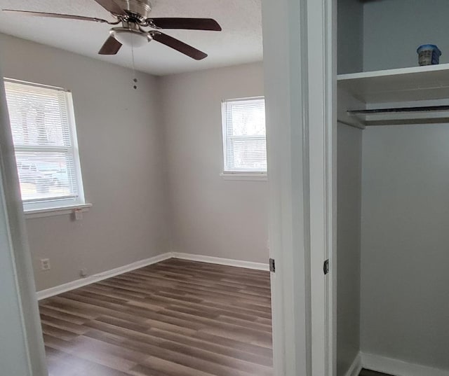 unfurnished bedroom with hardwood / wood-style floors, ceiling fan, and a closet