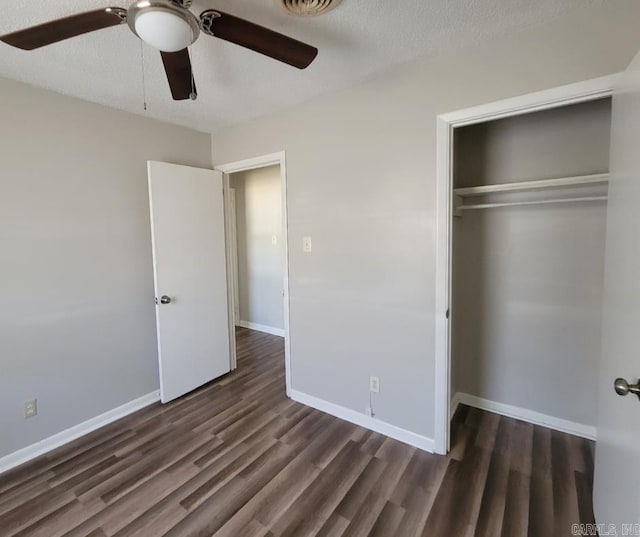 unfurnished bedroom with ceiling fan, dark hardwood / wood-style floors, a textured ceiling, and a closet