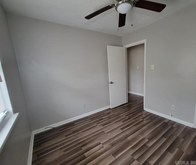 unfurnished room featuring a textured ceiling and dark hardwood / wood-style flooring