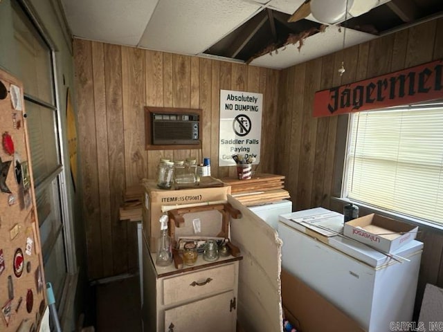 kitchen featuring an AC wall unit and wood walls