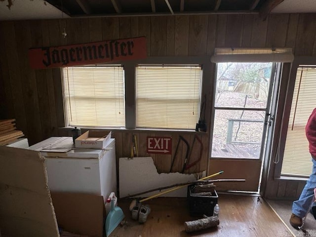 misc room featuring hardwood / wood-style floors and wood walls