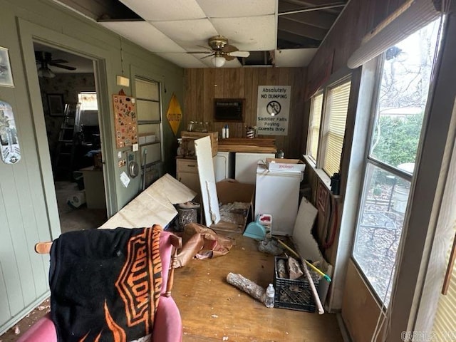 interior space with washer / clothes dryer, ceiling fan, a paneled ceiling, and wooden walls