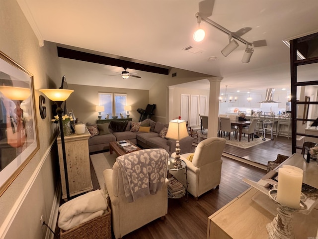 living room with decorative columns, dark hardwood / wood-style floors, track lighting, and ceiling fan