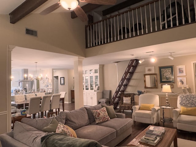 living room featuring beamed ceiling, wood-type flooring, a high ceiling, and ceiling fan with notable chandelier