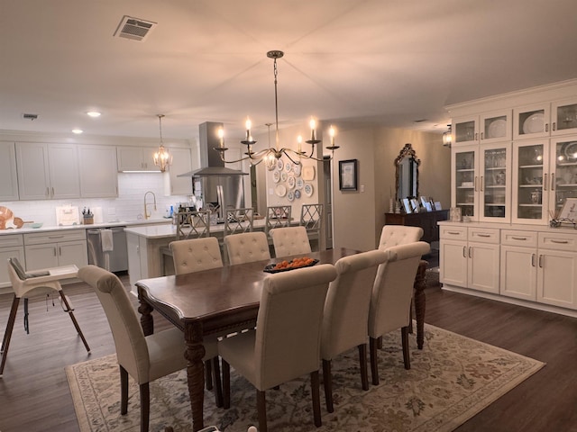 dining area featuring an inviting chandelier, dark hardwood / wood-style floors, and sink