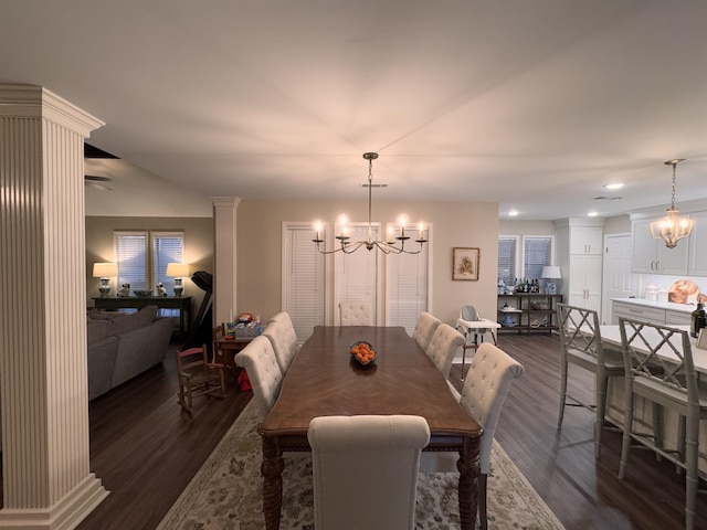 dining space with a notable chandelier, dark hardwood / wood-style floors, and ornate columns