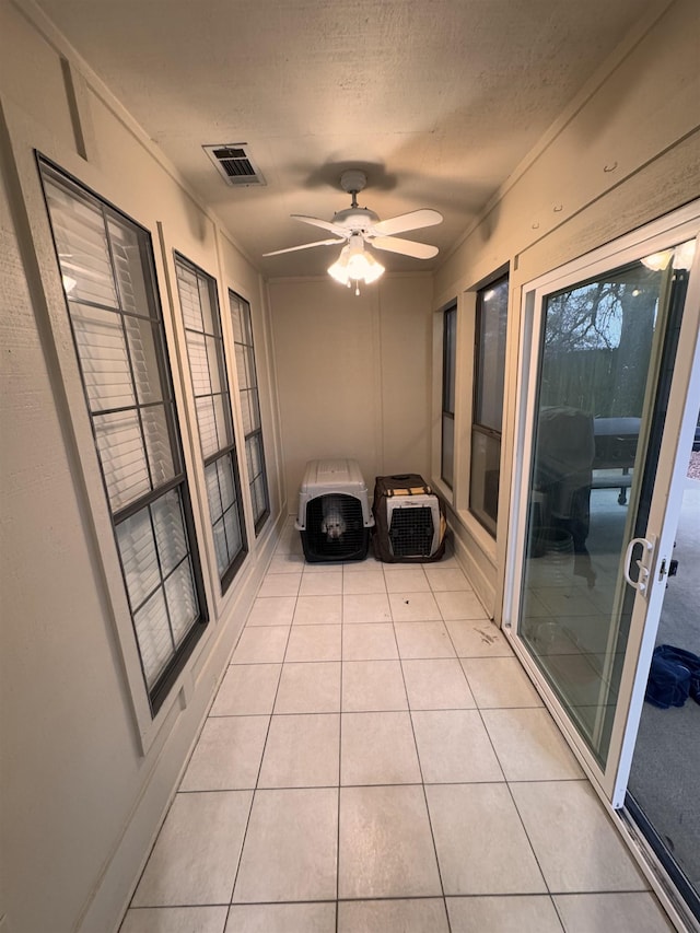 unfurnished sunroom featuring ceiling fan