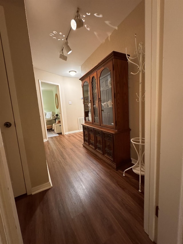 hallway with track lighting and dark hardwood / wood-style flooring